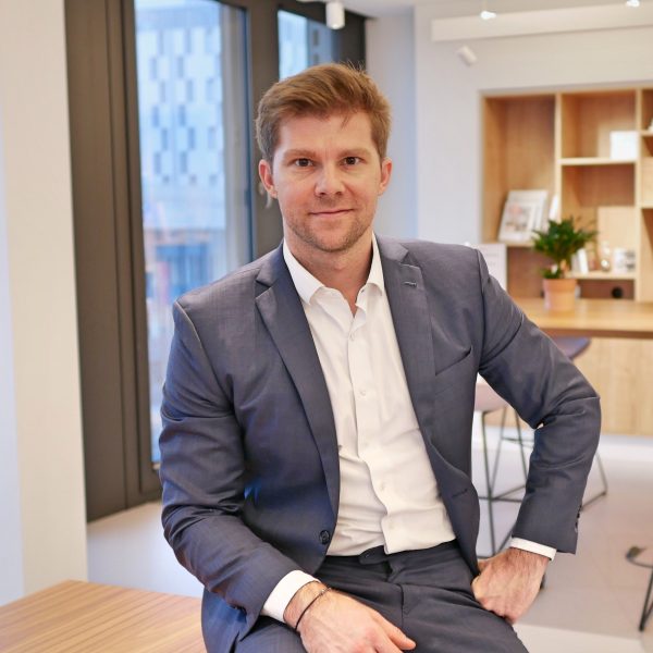 Gerry Eder_sitzend auf Tisch im Buero